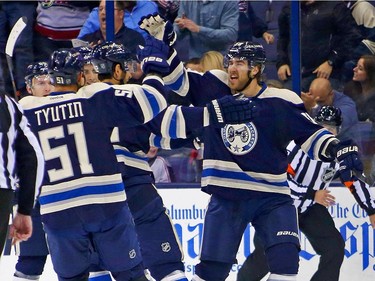 David Savard #58 of the Columbus Blue Jackets is congratulated by his teammates after scoring a goal during the first period.