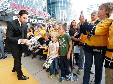 James Neal #18 of the Nashville Predators signs for some young fans as players arrive on the Gold Carpet for opening night against the Ottawa Senators.