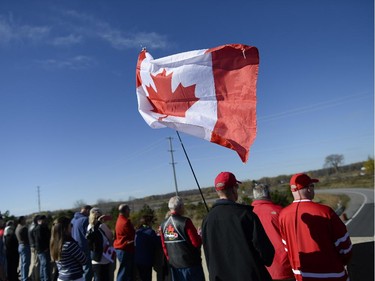 People gathered at Bankfield at the 416 to pay respects as the escort with the body of Nathan Cirillo is transported by hearse from Ottawa via Highway of Heroes to Hamilton on Friday, Oct. 24, 2014.