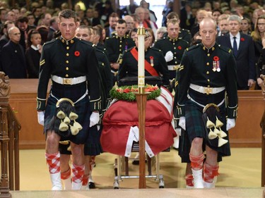 People rise as the coffin of Cpl. Nathan Cirillo is carried by pallbearers at his regimental funeral service.