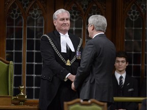 Prime Minister Stephen Harper shakes hands with as Sergeant-at-Arms Kevin Vickers in the House of Commons on Thursday October 23, 2014 in Ottawa.