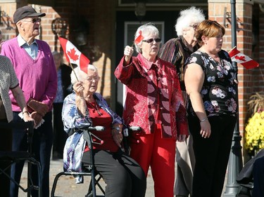 Residents of a nearby senior's home on Hunt Club Road, clap and wave flags as the procession carrying the casket of Cpl. Nathan Cirillo makes its way from Ottawa home to Hamilton Friday, October, 24, 2014.