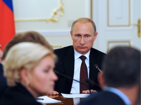 Russian President Vladimir Putin chairs a meeting with Government members in his country residence of Novo-Ogaryovo outside Moscow on October 3, 2014. Ukrainian troops and pro-Russian rebels clashed on October 3, 2014 around the flashpoint city of Donetsk, while trading blame over the death of a Swiss aid worker, four weeks into their shaky truce.