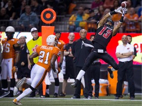 The Ottawa Redblacks' Khalil Paden leaps to make the play, but fails to come down with the ball as the B.C. Lions' Ryan Phillips close in on Saturday, Oct. 11, 2014, in Vancouver.