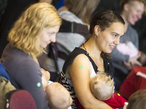 Sarah Bricknell with Elijah, left, and Biana de Boer with Natalia, right, take part in the Bistro Bebe Breastfeeding Challenge in Jean Pigott Place at Ottawa City Hall on Saturday.