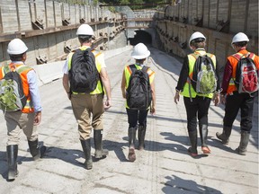 Second from left, Ottawa Mayor Jim Watson, Ontario Premier Kathleen Wynne, center, and Ottawa Deputy City Manager Nancy Schepers, second from right, walk into  the Confederation Line Light Rail Train tunnel during a a tour Monday, August 11, 2014.