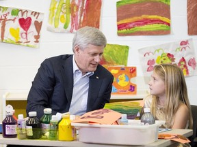 Prime Minister Stephen Harper does arts and crafts with a student at the Joseph and Wolf Lebovic Jewish Community Campus in Vaughan, Ont., on Wednesday before his tax-break announcement.