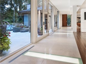 Glass panels in the floor of this Barry Hobin-designed home let natural daylight flow through to the lower level during the day while diffused light from below creates an interior glow at night.