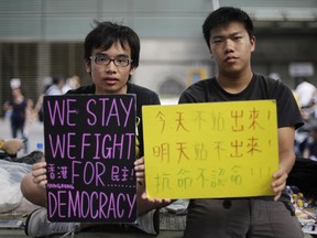 Student protesters sit with signs on their fight for democracy in Hong Kong Wednesday, Oct. 1, 2014.