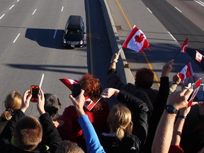The procession carrying the body of Cpl. Nathan Cirillo passes through Kingston, Ont., on Friday, Oct. 24, 2014. The 24-year-old reservist was gunned down as he stood ceremonial guard at the National War Memorial in Ottawa on Wednesday.