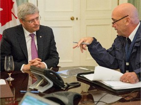 This photo provided by the Prime Minister's office shows the head of RCMP Bob Paulson briefs Canadian prime Minister Stephen Harper on the shootings at  Parliament Hill in Ottawa on Wednesday Oct. 22, 2014.  A soldier standing guard at the National War Memorial was shot by an unknown gunman and people reported hearing gunfire inside the halls of Parliament.  (AP Photo/Canada Prime Minister Office)
