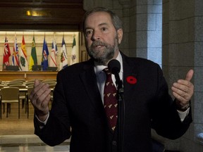 Official Opposition leader Tom Mulcair addresses reporters in front of the caucus room where, last week, several NDP MPs were in lockdown after a gunman's attack.