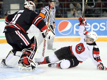 Travis Barron, right, loses his footing and slides into goalie Brent Moran in the first period as the Ottawa 67's take on the Niagara Ice Dogs in their home opener at the renovated TD Place arena.