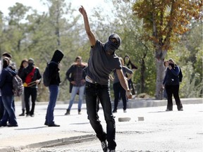 A demonstrator throws a stone at anti-riot police outside of the Middle Eastern Technical University (METU) in Ankara on October 9, 2014 denouncing Turkey's unwillingness to intervene militarely against Islamic State (IS) forces in the Syrian town of Ain al-Arab, known as Kobane by the Kurds.
