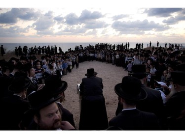 Ultra-Orthodox Jews of the Hassidic sect Vizhnitz listen to their rabbi on a hill overlooking the Mediterranean sea as they participate in a Tashlich ceremony in Herzeliya, Israel, Thursday, Oct. 2, 2014. Tashlich, which means "to cast away" in Hebrew, is the practice by which Jews go to a large flowing body of water and symbolically "throw away" their sins by throwing a piece of bread, or similar food, into the water before the Jewish holiday of Yom Kippur. The major Jewish holiday coincides with the Muslim holiday of Eid al-Adha, the first time this has happened since 1981.