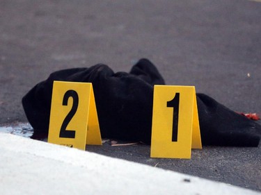 What appears to be a piece of clothing on the street, as OPP investigate a death on Charles St. near the corner of Daniel St. South in Arnprior, Ontario, Thursday, October 2, 2014. Paramedics found an injured women on the street near a blue pick-up truck, and took her to hospital, where she died. A man was arrested at the scene.