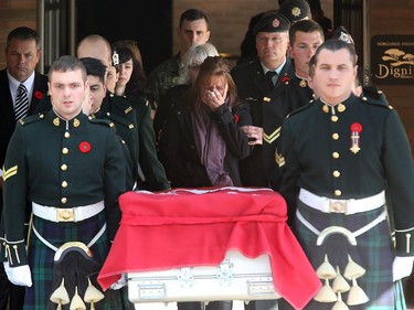 With family, Cpl. Nathan Cirillio's mother, Kathy Cirillo (centre) follows the casket carrying her son, Cpl. Nathan Cirillo, out of McEvoy-Shields funeral home in Ottawa Friday afternoon as it starts its escorted procession home to Hamilton October 24, 2104.