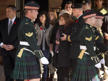 With family, Cpl. Nathan Cirillio's mother, Kathy Cirillo (centre) watches in tears as the Argyll and Sutherland Highlanders march past after putting the casket carrying her son, Cpl. Nathan Cirillo, into a hearse in Ottawa for its long escorted procession home to Hamilton October 24, 2104.