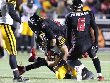 Zach Collaros of the Hamilton Tiger-Cats is sacked by Travis Brown of the Ottawa Redblacks during first half CFL action.