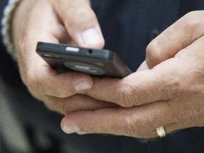 Ottawa Fire Service chief John DeHooge uses his cell phone to call on friends to make his bail. City of Ottawa Emergency and Protective Services Department where jailed to raise funds for the United Way campaign. EPS Chiefs where taken into custody and incarcerated at the Carlingwood Mall. The event raised $1,600. (Pat McGrath / Ottawa Citizen)