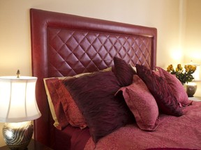 A cranberry leather upholstered headboard fits in with a gold colour scheme.