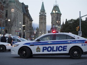 Police remain on the scene Oct 23 at the Cenotaph where a soldier was shot dead Oct 22. The gunman was later killed when he stalked the halls of Parliament Hill.
