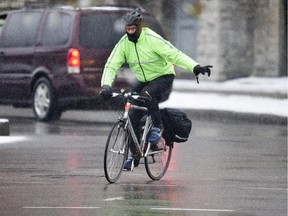 A cyclists at the intersection of Laurier and Elgin. Expected snowfall up to 10cms with a high of plus 1C.