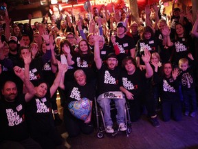 25-year-old Kyle Humphrey (middle) is surrounded by family and friends as he poses for a photo at his surprise 25th birthday party at Lone Star bar in Ottawa on November 15, 2014. Overcoming various challenges ranging from Spina Bifida, Hydrocephalus, and arnold chair malformation, Kyle has had upwards of 93 operations.