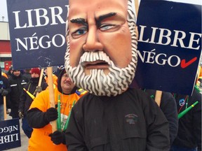 A man wearing a giant head in the likeness of Quebec Premier Philippe Couillard attends the one day strike of municipal workers at Robert Guertin Arena on Wednesday.