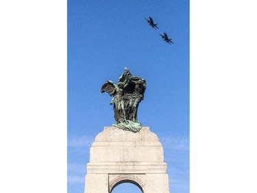 A pair of CF-18 fighter jets soar over the National War Memorial the Remembrance Day ceremony in Ottawa Tuesday, November 11, 2014.