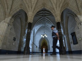 A security guard walks past the Hall of Honour in Centre Block on Parliament Hill in Ottawa on Thursday October 23, 2014. The House of Commons is back in action, kicked off by an exhilarating show of support for the sergeant-at-arms of the House of Commons, who was among those who opened fire Wednesday on the gunman who stormed Parliament Hill.