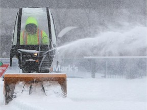 A worker clears snow from the rink of dreams at City Hall during a spring snowstorm in Ottawa on Saturday, March 22, 2014. Cole Burston/Ottawa Citizen #116499