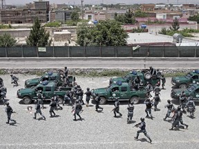 Afghan police prepare for a patrol in Kabul, Afghanistan, Friday, June 13, 2014. Afghan police and soldiers manned checkpoints at almost every intersection Thursday, searching vehicles and frisking drivers in a massive security operation ahead of elections to choose a new president to guide the country after international combat forces withdraw.