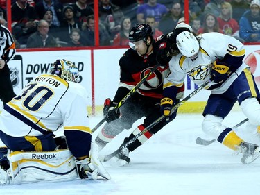 Alex Chiasson, middle, of the Ottawa Senators drives to the net of Carter Hutton of the Nashville Predators as he is defended by #19 Calie Jarnkrok during first period NHL action.