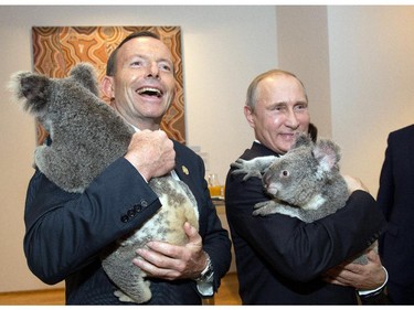 Australia's Prime Minister Tony Abbott laughs, as he and Russia's President Vladimir Putin get cosy with  Koalas before the start of the first G20 meeting in Brisbane. Putin said he would be leaving the G20 summit early Saturday — maybe with a new pet?