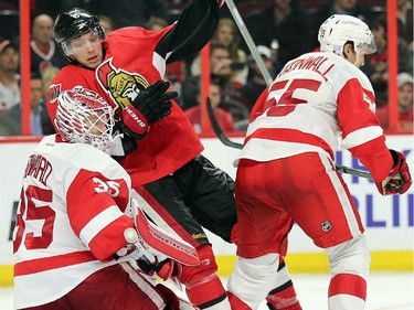 Bobby Ryan gets checked into Jimmy Howard, left, by Niklas Kronwall in the third period.