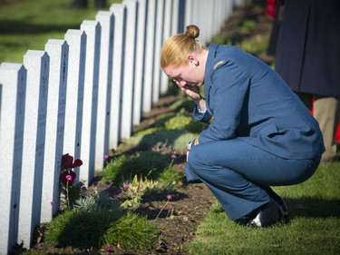 Captain Anne Gray takes a moment after the Remembrance Day ceremony to pay respects to a very close family friend who she considered a virtual grandfather. The service was held at the National Military Cemetery at Beechwood Cemetery Tuesday November 11, 2014.
