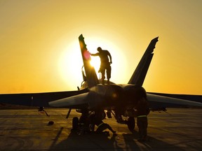 Royal Canadian Air Force ground crew perform post flight checks on a CF-18 fighter jet in Kuwait after a sortie over Iraq during Operation IMPACT on November 3, 2014.
 
Photo: Canadian Forces Combat Camera, DND
IS2014-5026-03