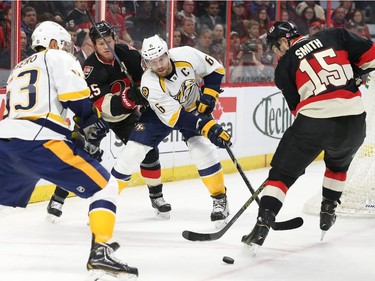 Chris Neil, second from left, and Zack Smith, right, of the Ottawa Senators battle against Mike Ribeiro, left, and Shea Weber of the Nashville Predators during first period NHL action.