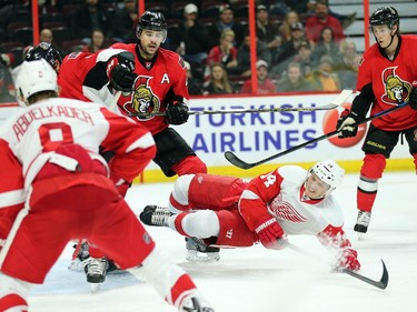Chris Phillips knocks Gustav Nyquist to the ice in front of Kyle Turris, right, looking on in the second period.