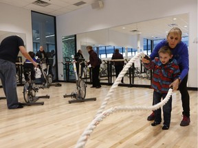 Clark McEachran, 4, learns how to use some fitness equipment during a public tour at the grand opening of the new 160,000 square foot state-of-the-art Minto Recreation Complex in Barrhaven on Saturday morning, Nov. 29, 2014. Mayor Jim Watson was joined by fellow councillors and The Minto Group CEO Michael Waters for the official ceremony before public tours of the facility, which features two NHL sized skating rinks, a six lane-25 metre lap swimming pool with diving boards, a gymnasium, an artificial turf sports field, fitness facilities, a cafe and free Wi-Fi.