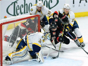 Ottawa Senators' Clarke MacArthur, middle left, and Alex Chiasson fight for the puck at the net with Nashville Predators' Carter Hutton, clockwise from bottom, Roman Josi and Colin Wilson during first period NHL hockey action.