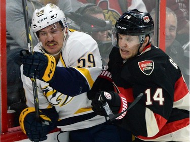 Ottawa Senators' Colin Greening, right, slams Nashville Predators' Roman Josi into the boards during first period NHL hockey action.
