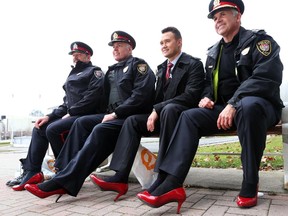 From left, Constables Charles Benoit and Mike Maloney, Sgt. Colin Stokes and Ottawa Police Chief Charles Bordeleau (R) and other members of the Ottawa police joined the launch of the Shine the Light campaign by walking from their headquarters to the Ottawa City Hall in women's shoes.
