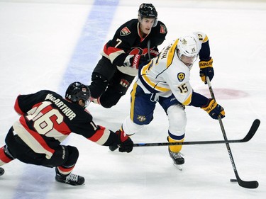 Nashville Predators' Craig Smith skates the puck away from Ottawa Senators' Clarke MacArthur, left, and Kyle Turis during first period NHL hockey action.