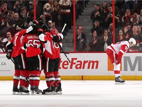 Erik Karlsson #65 of the Ottawa Senators celebrates his second period power play goal with teammates as Jonathan Ericsson #52 of the Detroit Red Wings looks away.