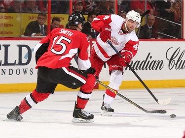 Jakub Kindl #4 of the Detroit Red Wings passes the puck against Zack Smith #15 of the Ottawa Senators.
