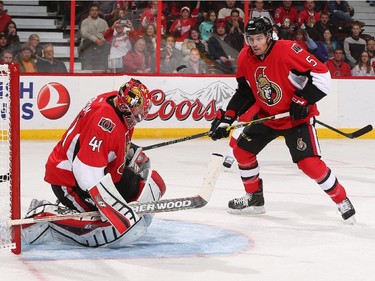 Craig Anderson #41 of the Ottawa Senators makes a save against the Detroit Red Wings as teammate Cody Ceci #5 looks to clear the rebound.