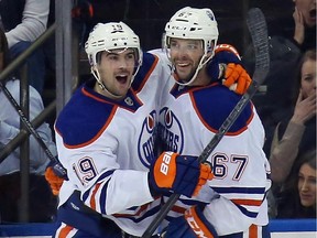 Benoit Pouliot #67 (R) of the Edmonton Oilers celebrates his goal at 8:29 of the second period against the New York Rangers  and is joined by Justin Schultz #19 (L) at Madison Square Garden on November 9, 2014 in New York City.
