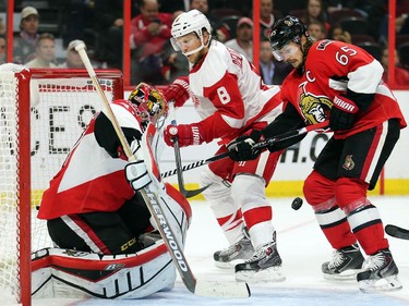 Erik Karlsson, right, holds off Justin Abdelkader moving in on goalie Craig Anderson in the second period.